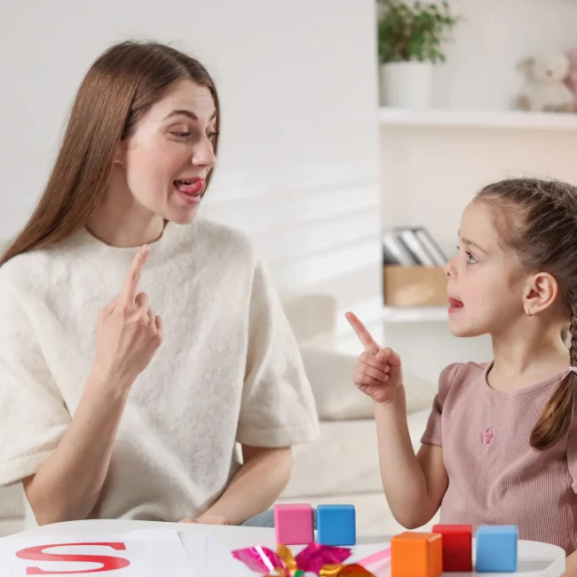 Speech-therapist-helping-a-little-girl-with-tongue-exercises-during-a-dysarthria-speech-therapy-sessions